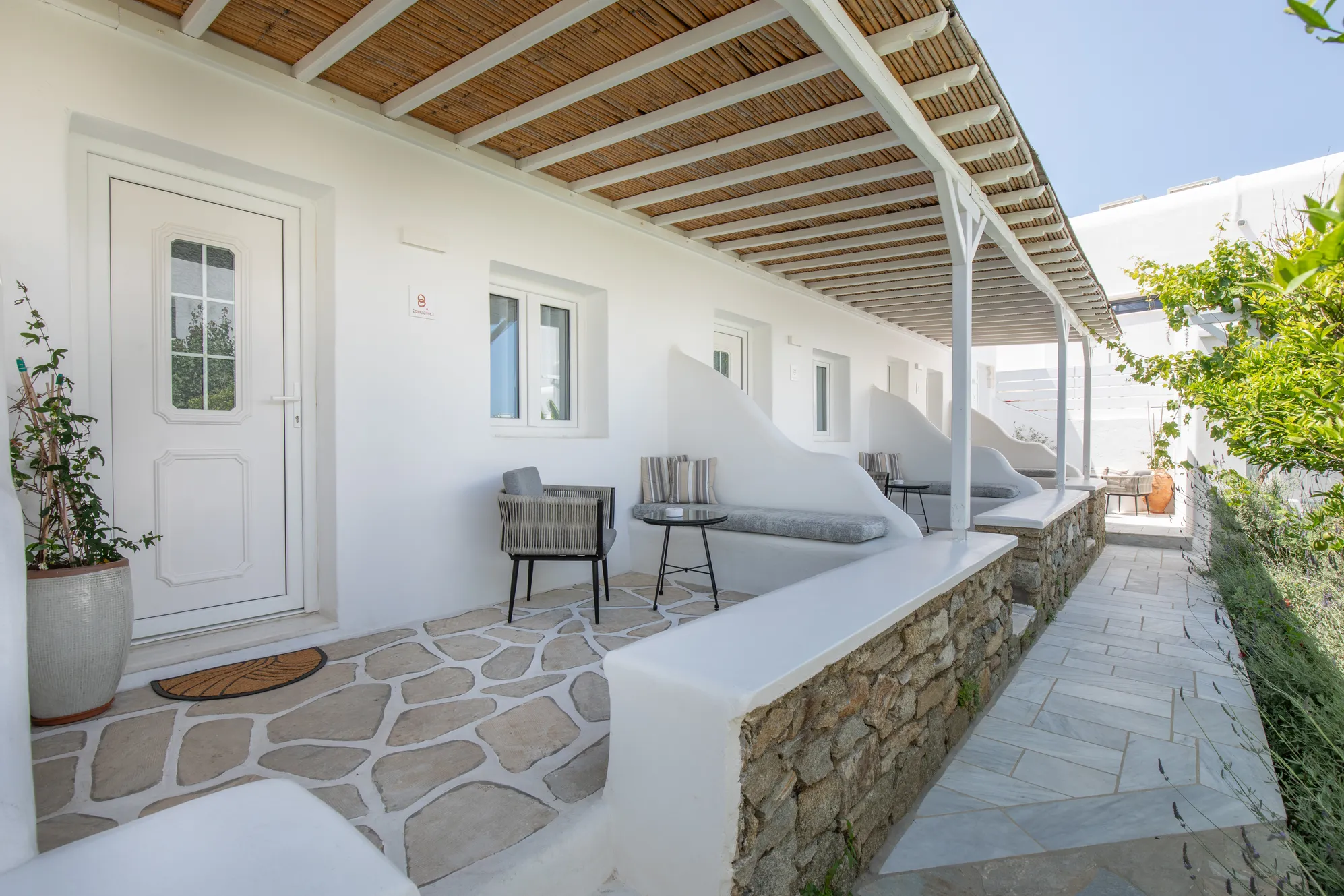 Deluxe Garden Suite · Covered terrace with reed pergola and stone wall outside the Deluxe Garden Suite